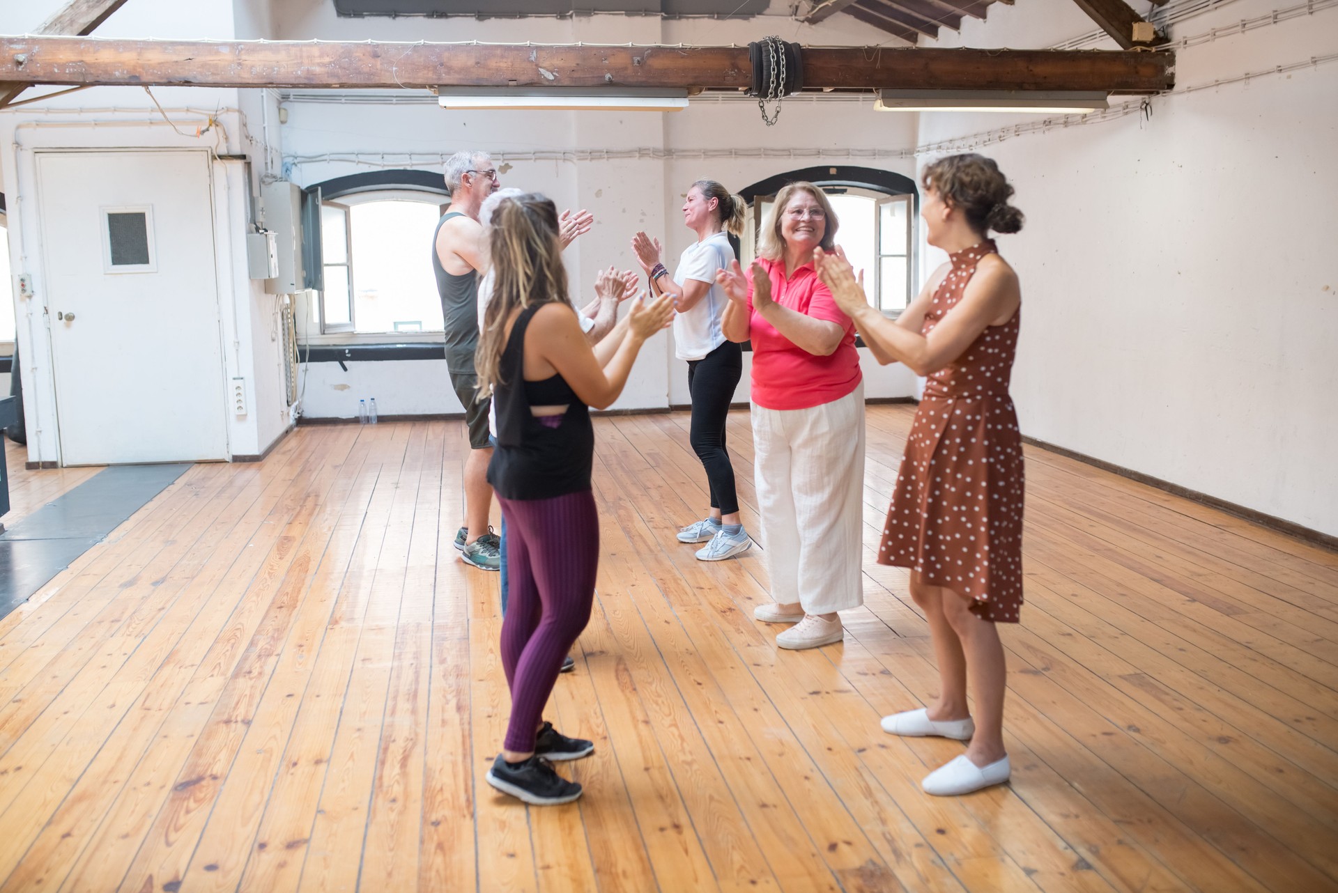 Happy retired dance students clapping their hands with teacher